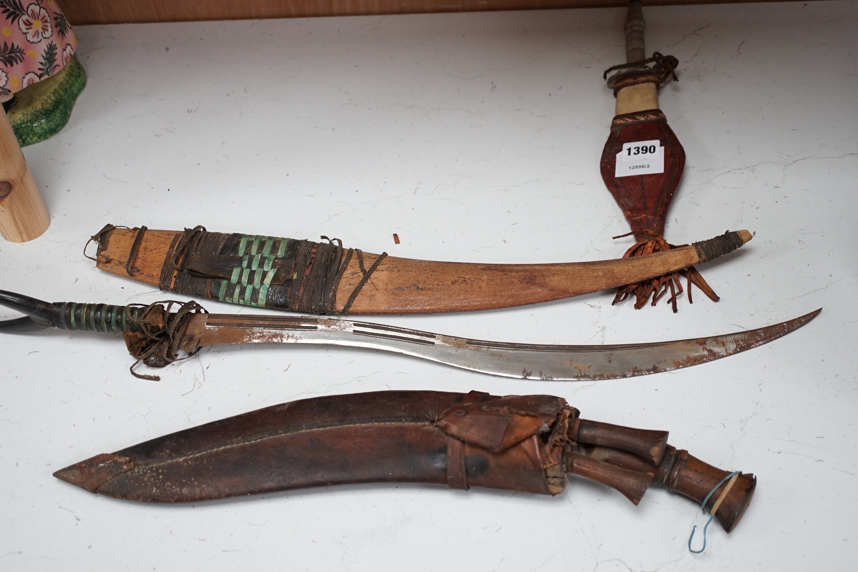 A kukri, a long dagger and sheath, a mace, and two African ebony busts